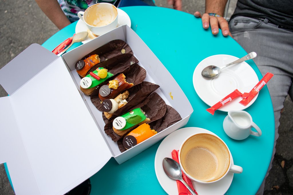 <img src="finished eclairs.png" alt="a box of finished eclairs on a coffee shop table">